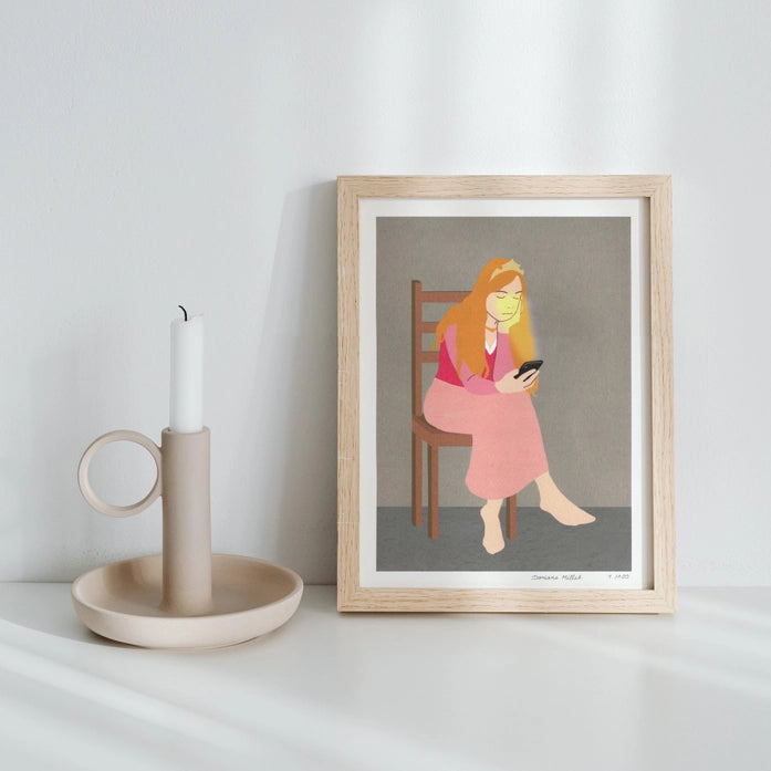 Giclée art print titled "Wait" by French illustrator Doriane Millet, showing a seated woman with long orange hair gazing at her phone, in soft pink tones and minimalist style. Printed on fine art archival paper, limited to 100 copies.