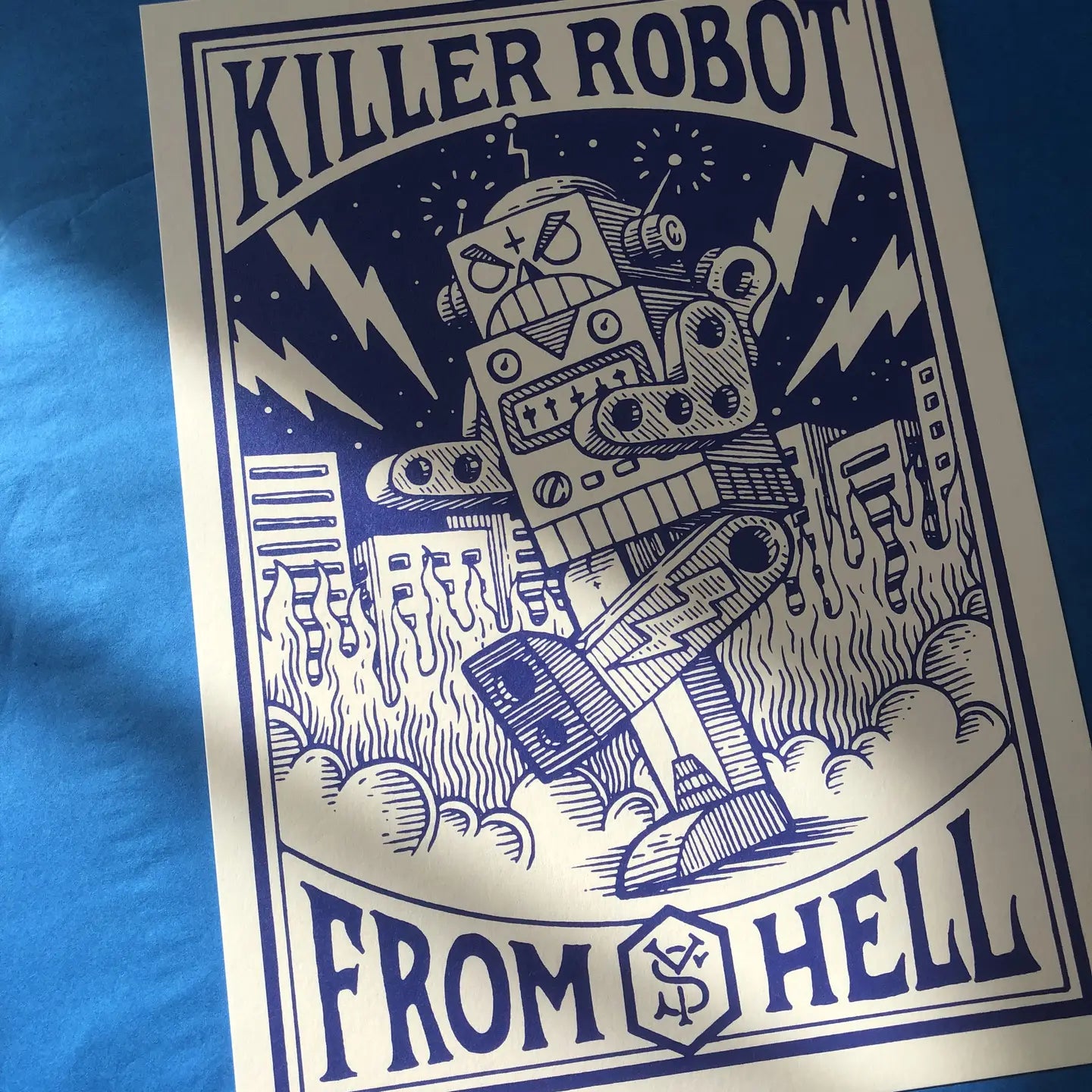 Killer Robot art print by Yeaaah! Studio, featuring a vintage comic-style blue robot destroying a city with lightning bolts and flames in the background. Retro pulp sci-fi illustration printed on 300g Old Mill Premium White paper, 30x40 cm, made in France, unframed.