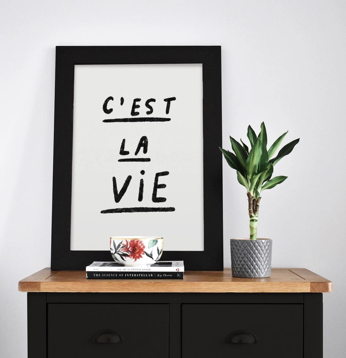 Black and white minimalist art print with handwritten French quote 'C'est la vie' by Just Cool Design – modern typography wall art for contemporary interiors, available at Galerie Frits