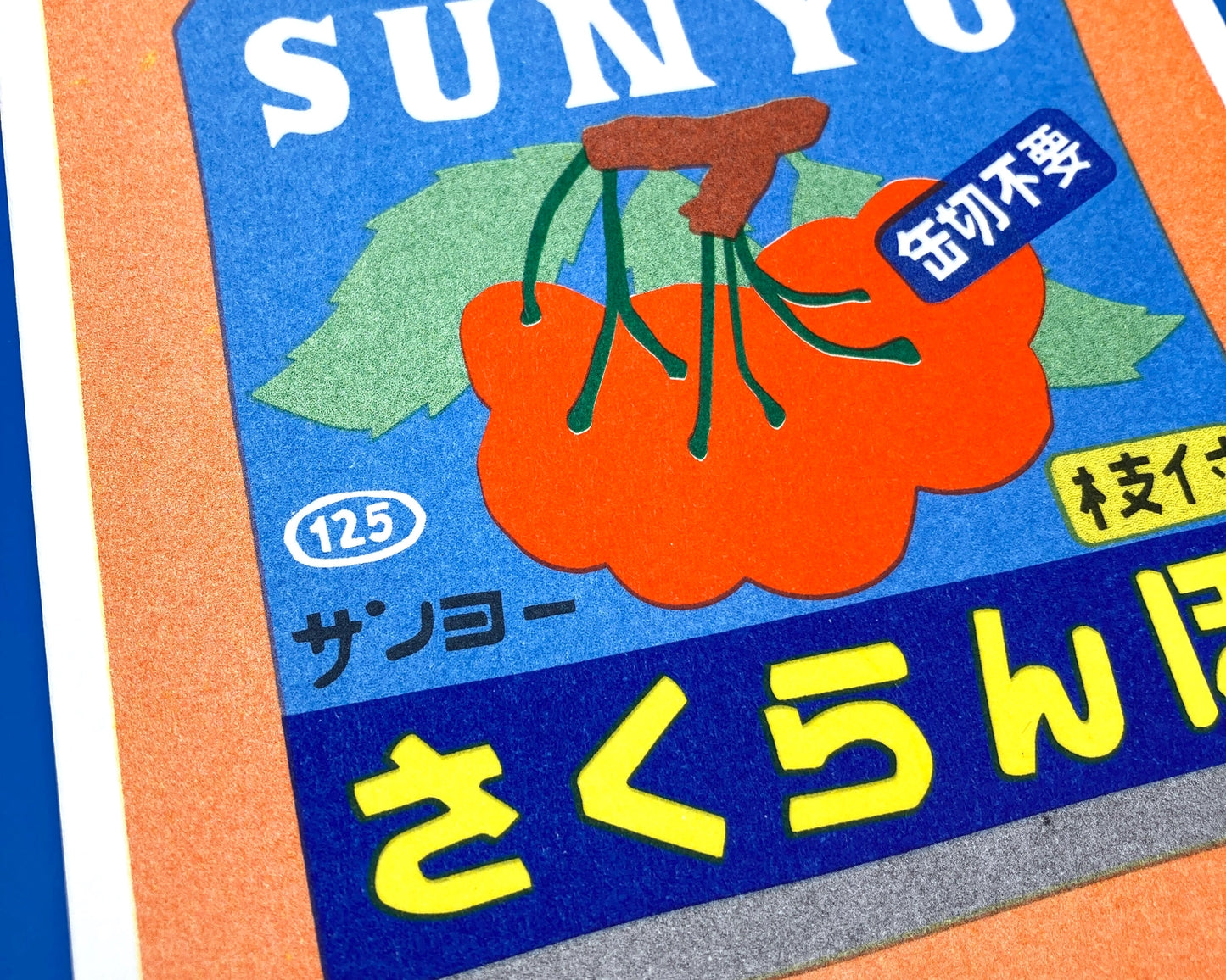 Colorful risograph art print of a Japanese can of cherries titled Canned Cherries by We Are Out Of Office, featuring bold retro typography and six-color rice-ink printing on Biotop 300g paper. Perfect wall art for pop art and Japanese design lovers.