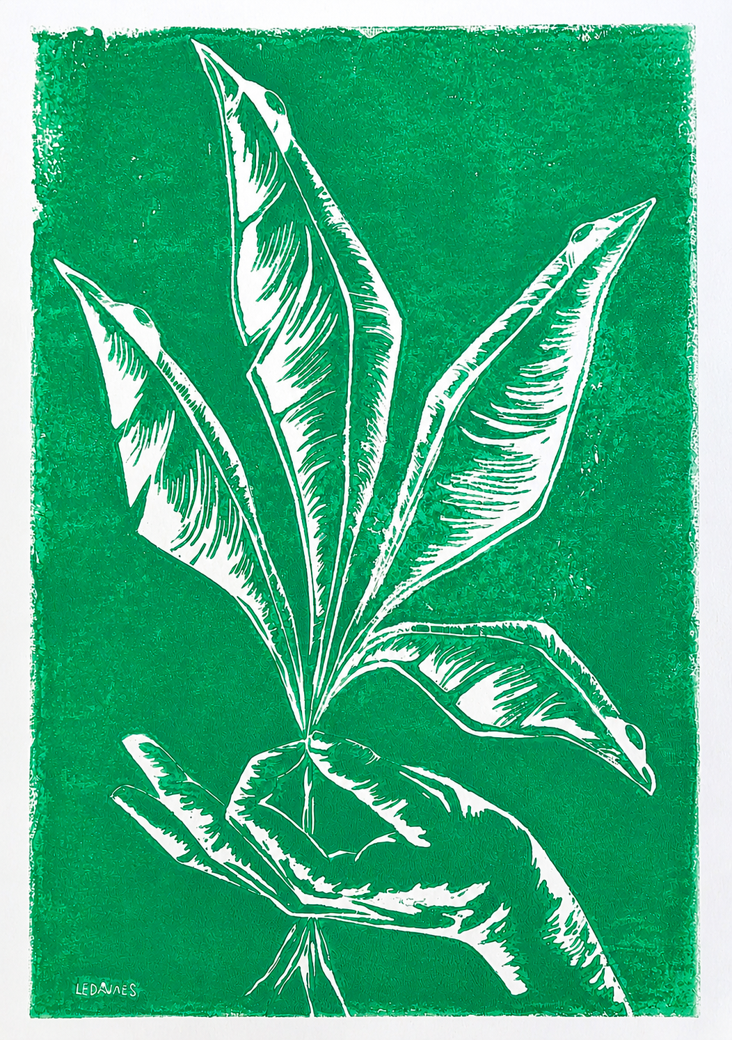 Handmade green botanical linocut print titled Vers by Belgian artist Leda Vaes featuring abstract tropical leaves and a hand in bold carved lines on textured paper, contemporary nature-inspired wall art in A3 format.