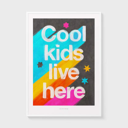Giclée art print by Just Cool Design with the phrase "Cool kids live here" in bold white letters over a bright rainbow background with stars, ideal for colorful children's rooms or playful modern decor.