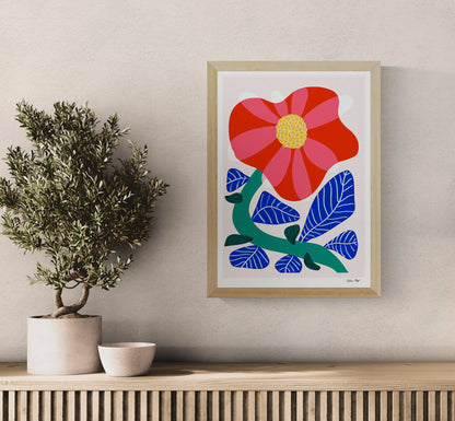 Vertical A3 giclée print of a large red and pink camellia with cobalt blue leaves and a green stem, created in Teresa Rego’s bold botanical style for colourful wall decor.