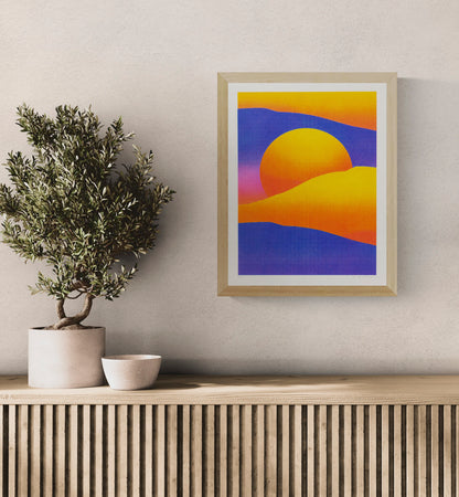 Purple and yellow dune landscape by PTRVRKD with a large orange sun, deep violet hills and warm yellow dunes, A3 vertical risograph print for colourful contemporary wall decor.