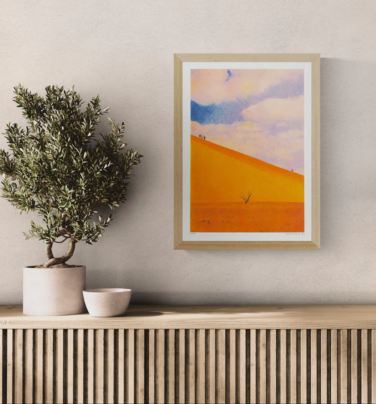 A3 portrait risograph by PTRVRKD showing vivid orange desert dunes, tiny walking figures, a lone tree and a soft blue-pink sky, ideal for modern wall art and home decor.