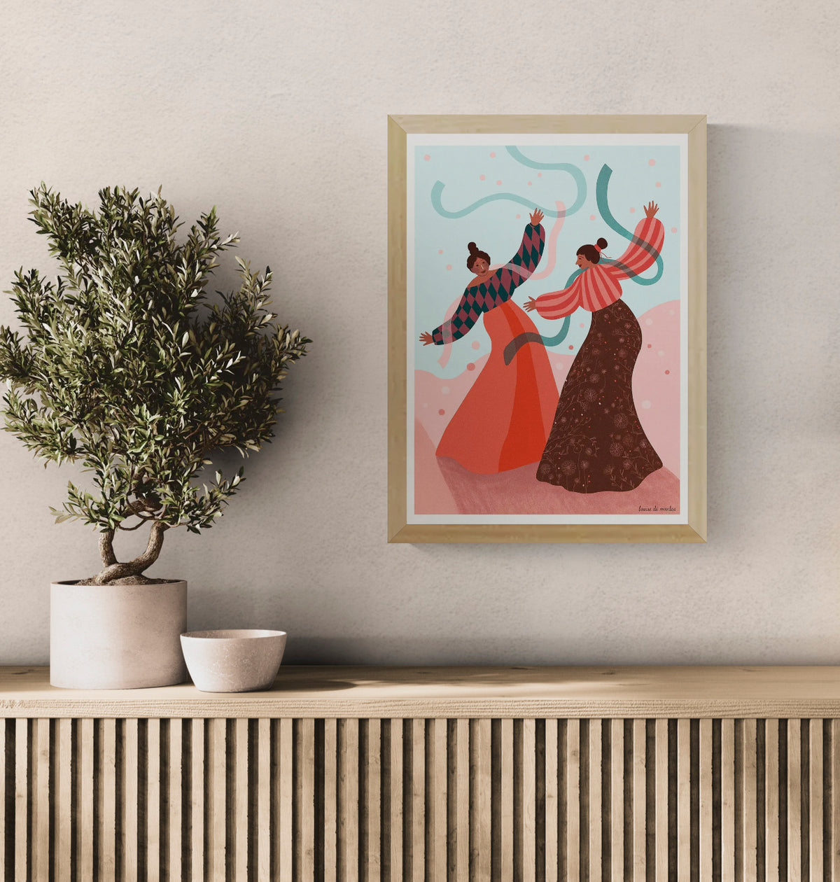 Joyful art print titled De dans by Belgian illustrator Louise de Meester, featuring two women dancing with flowing ribbons in a colorful landscape, printed in Belgium on high-quality A3 paper.