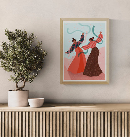 Joyful art print titled De dans by Belgian illustrator Louise de Meester, featuring two women dancing with flowing ribbons in a colorful landscape, printed in Belgium on high-quality A3 paper.