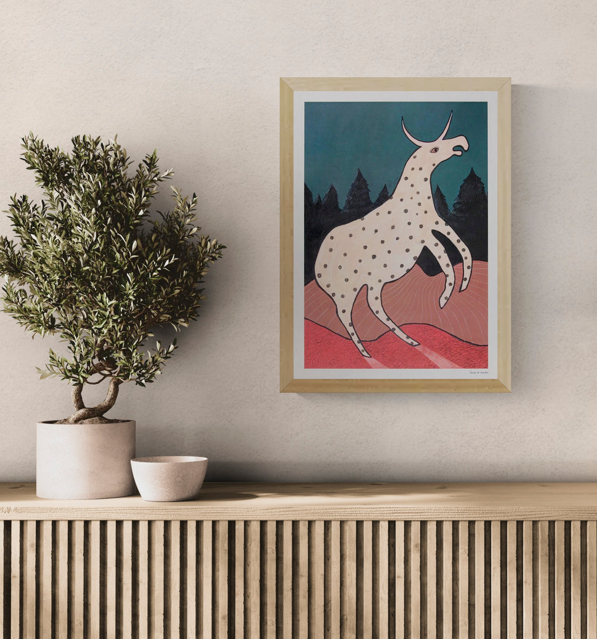 Surreal illustration titled Beest 2 by Louise de Meester, featuring a fantastical cream-colored creature with black spots and a single horn, set against a twilight forest backdrop with bold red terrain and a deep teal sky