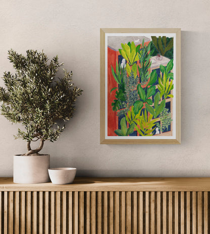 Bloom by Kim Timmermans – botanical illustration of lush green plants surrounding a terracotta building with small white figures at windows, whimsical and vibrant wall art available at Galerie Frits
