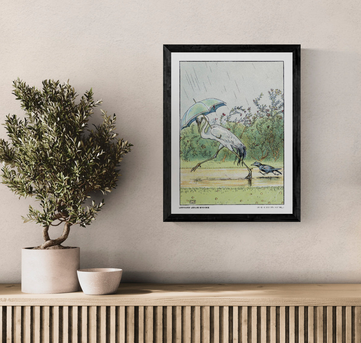 Vintage storybook illustration by Leonard Leslie Brooke of a white crane walking under a blue-green umbrella with a black crow in the rain. Soft green, blue and yellow tones. Vertical digital art print for whimsical wall decor.