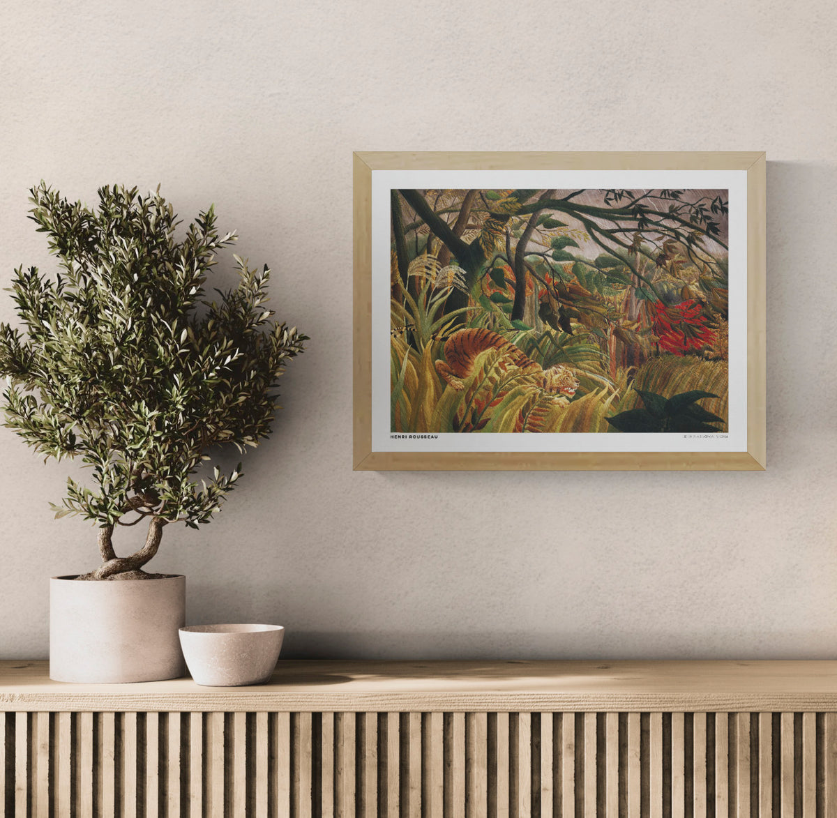 Henri Rousseau's Tiger in a Tropical Storm, a horizontal naïve-style jungle painting with a crouching orange tiger, lush green foliage, golden grasses and red tropical leaves. Digital wall art print for home decor.
