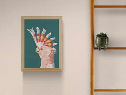 “Fashionista” by Floor 4 Productions – Digital art print of a pink cockatoo with vibrant yellow and orange crest on a muted green background, minimalist A4 wall decor made in Belgium.