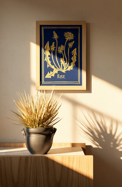 Blue and yellow handmade linocut print titled Rise by Belgian artist Leda Vaes featuring abstract dandelion flowers and organic botanical shapes on textured paper in A4 format.
