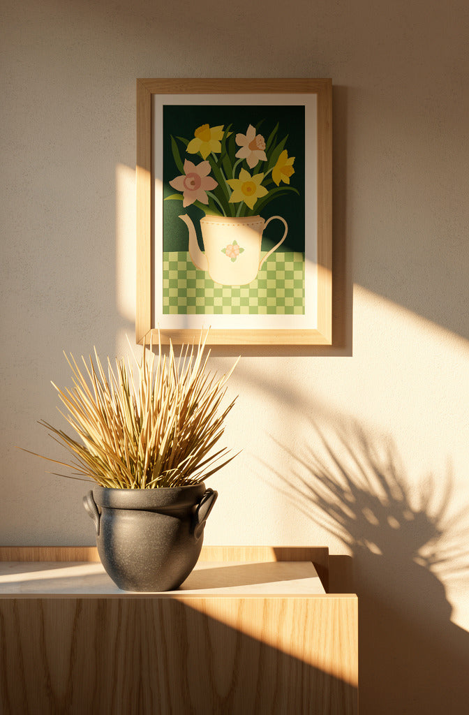 Botanical art print “Daffodils” by Leens featuring bright yellow daffodil flowers in a blue striped teapot on a pink table. Warm floral wall art with vintage colours for cozy kitchen and Scandinavian-style interiors.