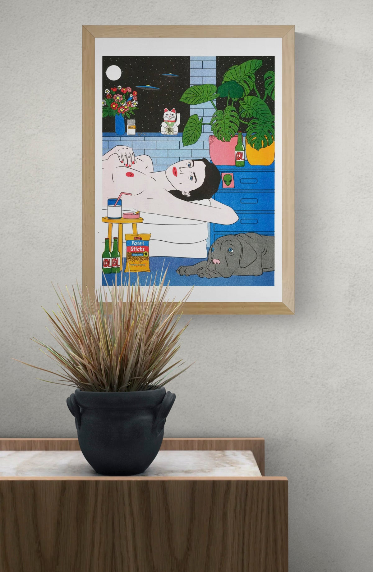 Colourful vertical risograph by Kine Andersen showing a reclining woman with a grey dog, tropical plants, flowers, beer bottles and UFOs, in blue, green, red and yellow tones, ideal as playful wall art.