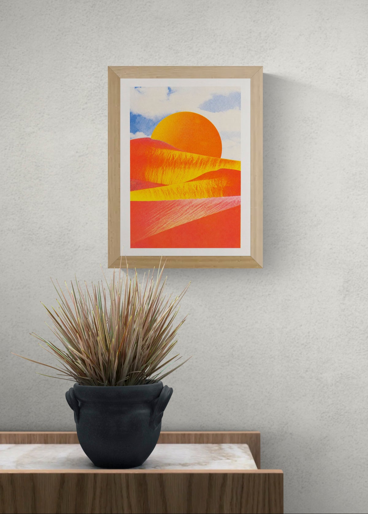 Abstract desert landscape risograph print by PTRVRKD, featuring vibrant orange and coral dunes, a golden sun, and a soft blue sky. Vertical A4 artwork for colorful modern wall decor.