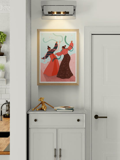 Joyful art print titled De dans by Belgian illustrator Louise de Meester, featuring two women dancing with flowing ribbons in a colorful landscape, printed in Belgium on high-quality A3 paper.