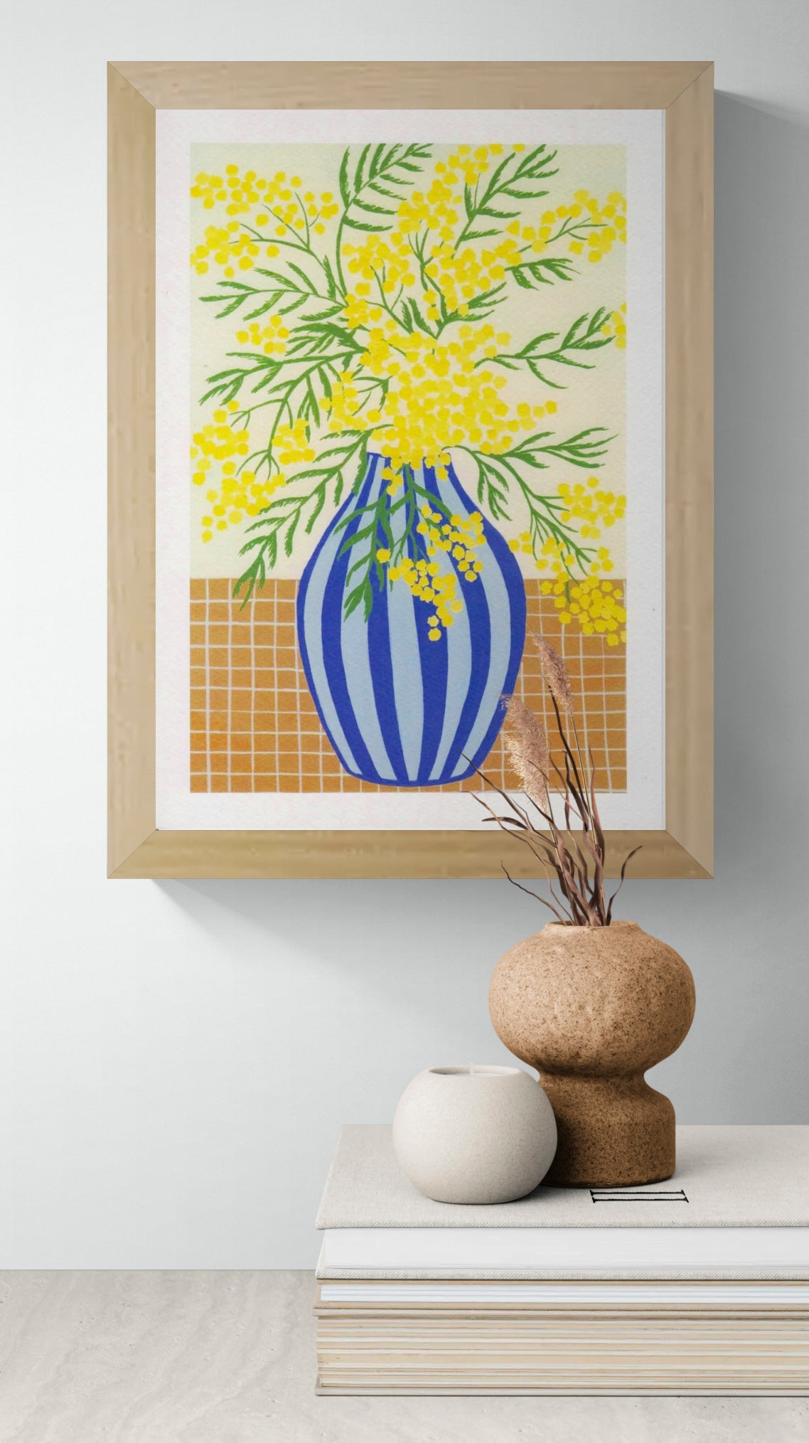 Botanical digital art print titled “Mimosa” by Belgian illustrator Leens, featuring vibrant yellow mimosa flowers in a blue striped vase on a tiled table, printed on textured fine art paper in A4 size.