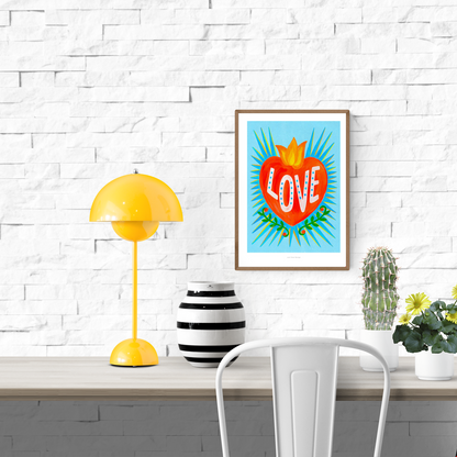 Bright Mexican folk-style illustration of a red heart with yellow flames and the word “LOVE” in white letters on a turquoise blue background, surrounded by green leaves – vibrant Giclée art print by Just Cool Design.