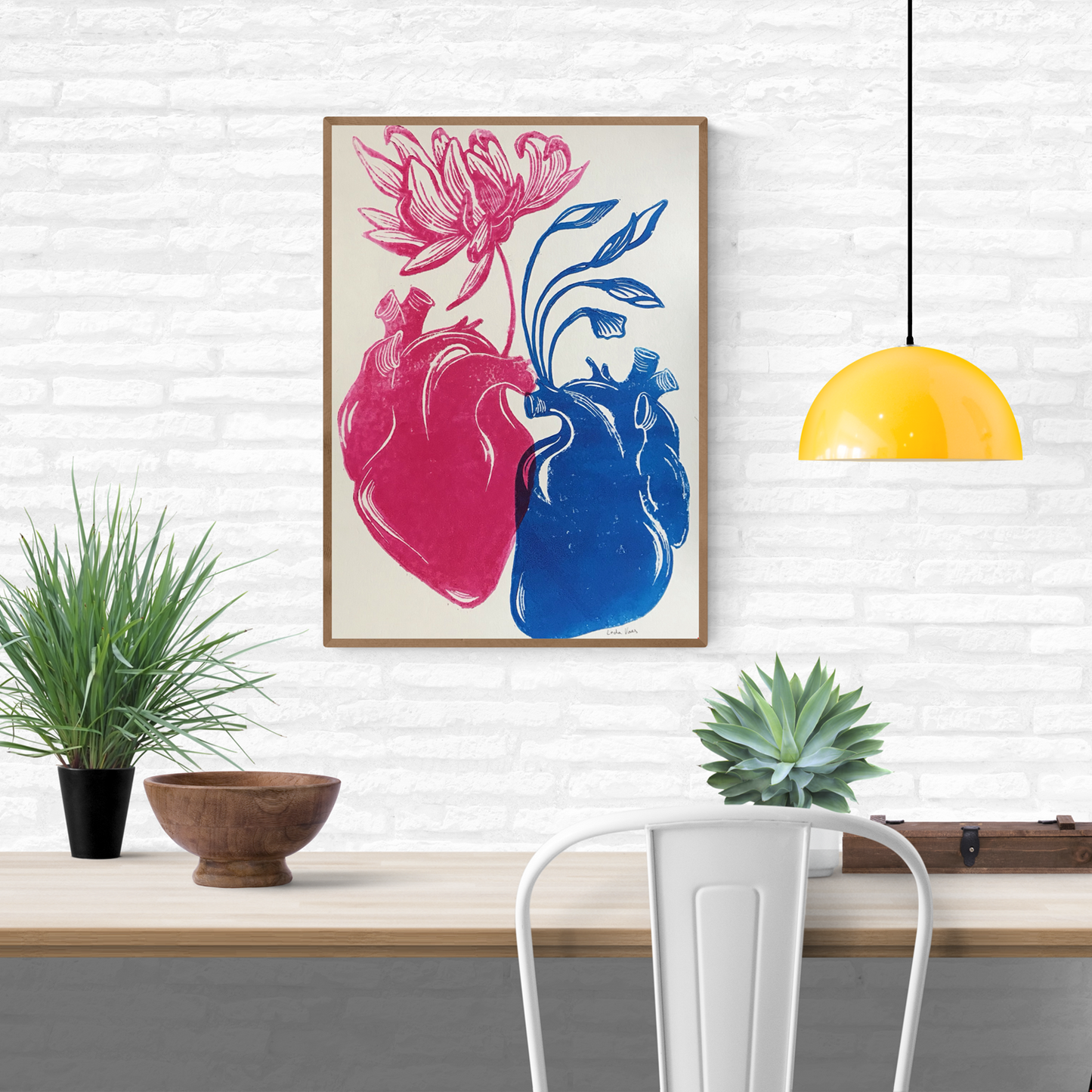 Handmade linocut print ‘Rebirth’ by Belgian artist Leda Vaes featuring a pink anatomical heart blooming into a flower and a blue heart growing flowing leaves, symbolizing renewal, connection, and new beginnings; high-contrast artistic print on textured paper.