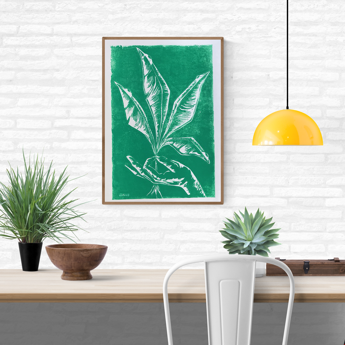 Handmade green linocut by Belgian artist Leda Vaes showing a hand gently holding tall, elongated plant leaves, carved in crisp white lines with a natural, minimalist, botanical aesthetic; nature-inspired art print for modern home décor.