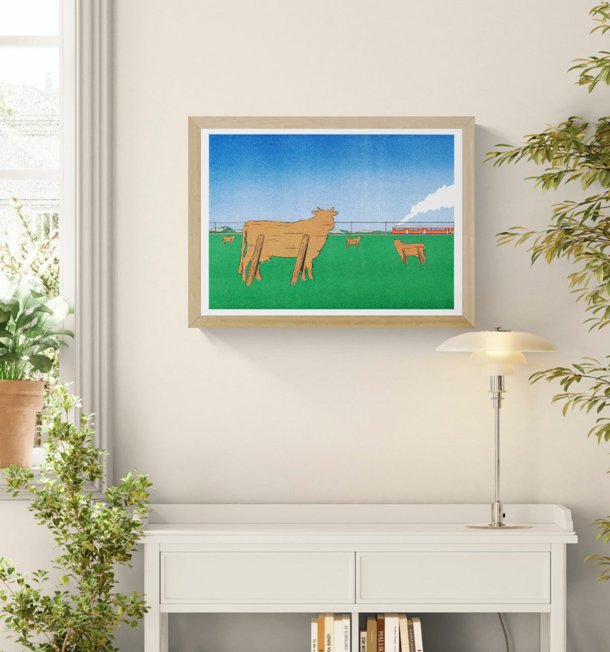 Landscape Risograph by Simon Bailly showing wooden cows in a green field watching a red train pass beneath a blue sky. Horizontal contemporary wall art with bold green, orange and blue tones.