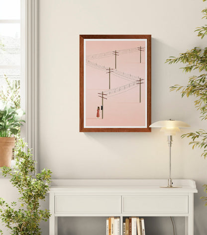 Minimalist art print titled 'Call' by Ana Yael, featuring a woman in a red dress using a vintage telephone on a wooden pole, with telephone wires stretching across a soft pink background – poetic and nostalgic wall art available at Galerie Frits