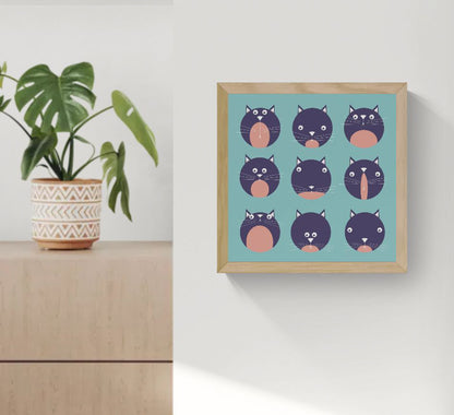 Illustration titled "9 Lives" by Studio Frits, featuring nine playful black and pink cartoon cat faces with varied expressions on a teal background. Perfect for cat lovers and modern home decor.