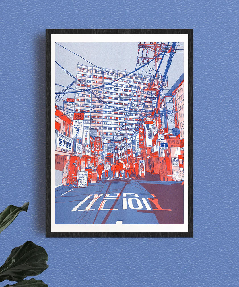 Vibrant risograph print by French illustrator Matthieu Surrel depicting a busy Seoul street filled with power lines, neon signs, and pedestrians, printed in bold red and blue tones on Munken White paper. A3 art print inspired by Myeong-dong’s paper and printing district, perfect for fans of contemporary urban illustration.