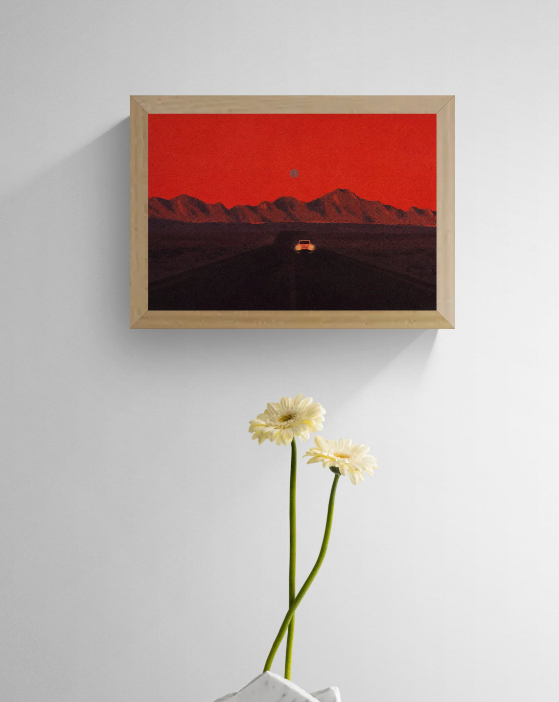 Namibia by Linde Raats, horizontal A6 giclée print showing a car driving toward dark mountains beneath a textured red sky, atmospheric wall art for modern home decor.