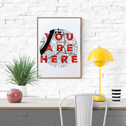 “You Are Here” A3 silkscreen print by De Zeverij featuring the city map of Antwerp with bold red typography over a black grid, handprinted with layered ink. Urban wall art for contemporary interiors.
