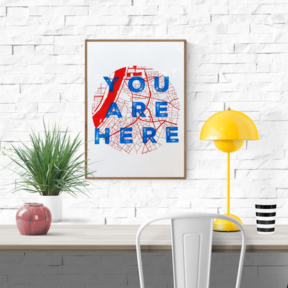 “You Are Here” A3 silkscreen print by De Zeverij featuring the city map of Antwerp with bold red typography over a black grid, handprinted with layered ink. Urban wall art for contemporary interiors.
