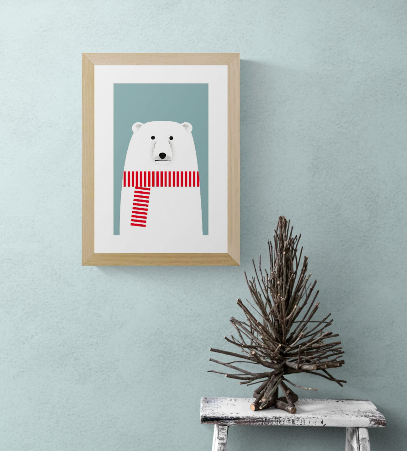Minimalist illustration by Studio Frits of a charming polar bear wearing a bold red and white striped scarf against a soft blue background. Clean lines and Scandinavian-inspired design make this print a playful yet stylish addition to modern nurseries, seasonal decor, or minimalist art collections