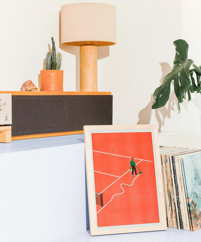 Roland-Garros art print by French illustrator Simon Bailly — risograph poster featuring a man marking tennis court lines with a curved stroke on a red clay field, surrounded by scattered tennis balls. Minimalist, witty, and modern design printed on Munken White paper by KIBLIND Workshop.