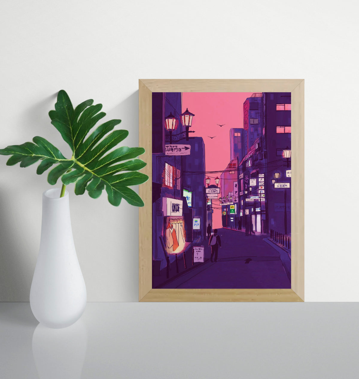 Fine art giclée print titled “Nights in Japan” by Valeria Maggiani featuring a cinematic Japanese city street at dusk with neon signs, warm shop lights, urban silhouettes, and a pink-purple evening sky, printed on 100% cotton textured paper A4 size, ideal for modern home decor and contemporary wall art in Belgium and Europe.