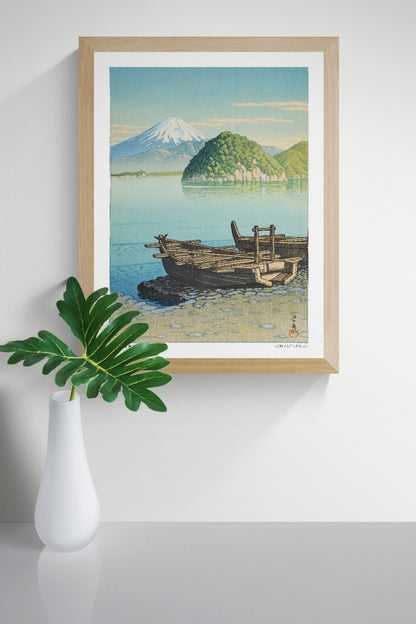 Morning in Mitohama by Kawase Hasui, a vertical Japanese landscape art print showing wooden boats on a turquoise lake, green hills and snow-capped Mount Fuji in soft blue and yellow tones. Digital print for peaceful wall decor.