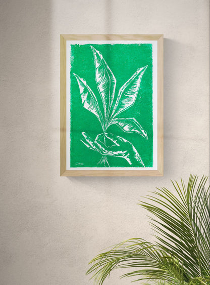 Handmade green botanical linocut print titled Vers by Belgian artist Leda Vaes featuring abstract tropical leaves and a hand in bold carved lines on textured paper, contemporary nature-inspired wall art in A3 format.
