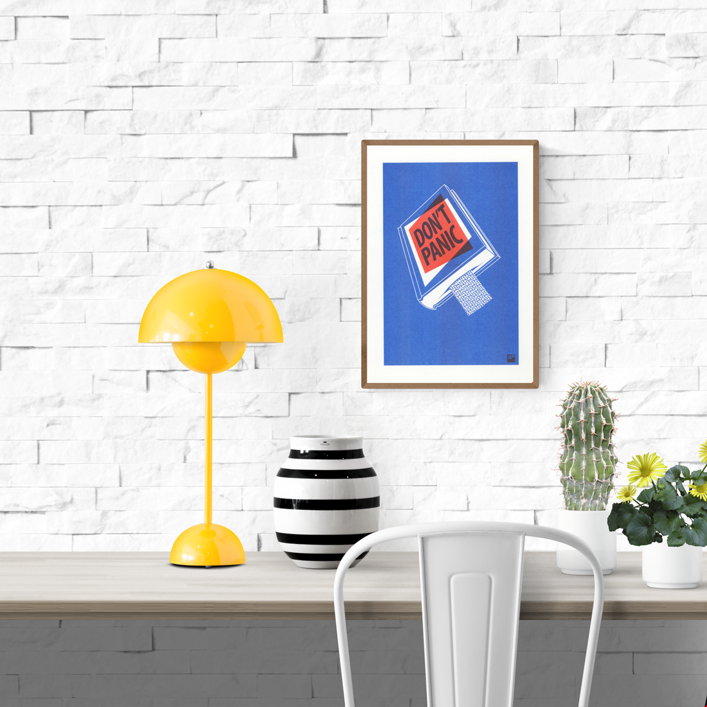 Risograph art print titled Book by VrijFormaat, featuring a blue book cover with bold red and black lettering reading “DON’T PANIC”, inspired by The Hitchhiker’s Guide to the Galaxy. Minimalist design printed in red and blue vegetable-based inks on Biotop paper, A4 size.