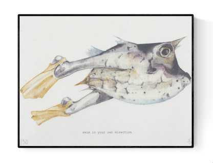 Surreal A5 art print titled Swim in your own direction by Belgian illustrator FAB. Features a watercolor fish with human legs and yellow fins, paired with the quote "Swim in your own direction". Printed on 300g Munker Pure rough paper, ideal for unique and inspirational home decor.