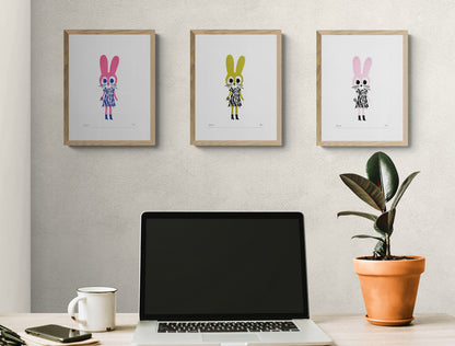 Plumo “Fancy Rabbit” A5 hand-pulled screenprint art print in fuchsia, golden and pink big-eyed rabbit character in black patterned dress and boots on white background, limited edition Belgian wall art for kids room or modern interior.