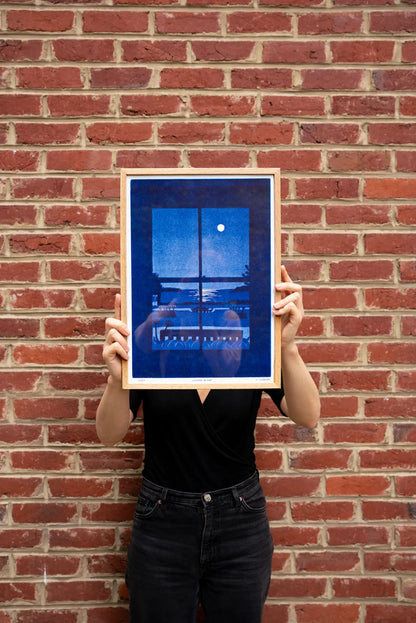 Summer Night by French illustrator Mathilde Solanet, A3 (29.7 x 42 cm) risograph print in 3 colors, limited edition of 150 signed and numbered copies. Artwork shows a serene moonlit coastal landscape through a window in rich blue tones. Printed on 150g Munken Print White paper, made in Belgium, unframed, packaged in protective sleeve with cardboard backing.